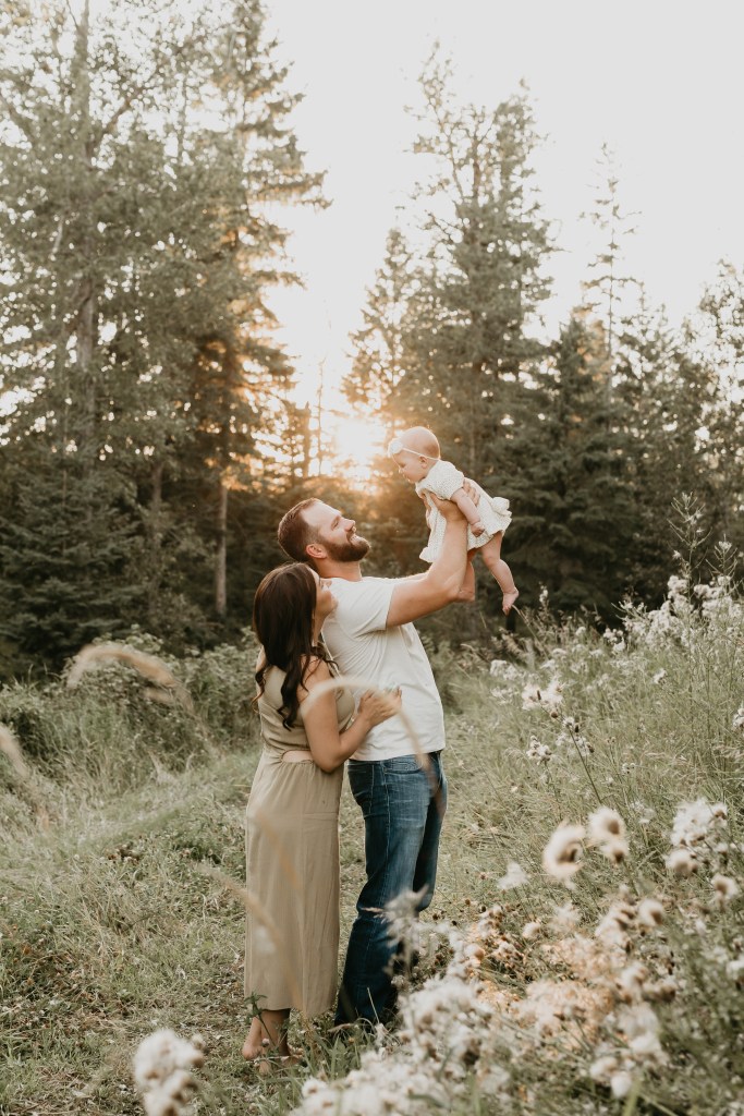 Family holding baby in sunset